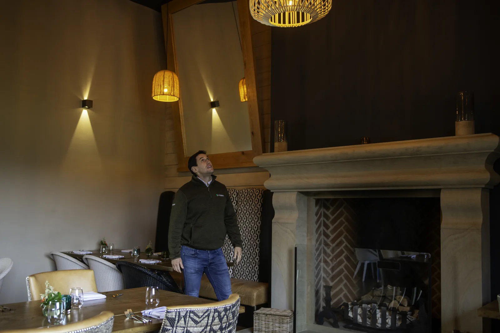 Dining area with a stone fireplace and warm wall lighting at Ye Horns Inn