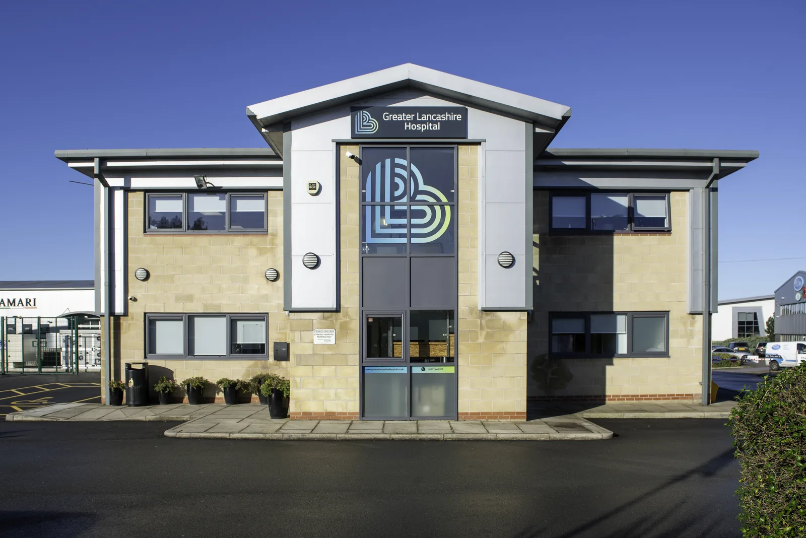 Front elevation of Greater Lancashire Hospital under a clear blue sky