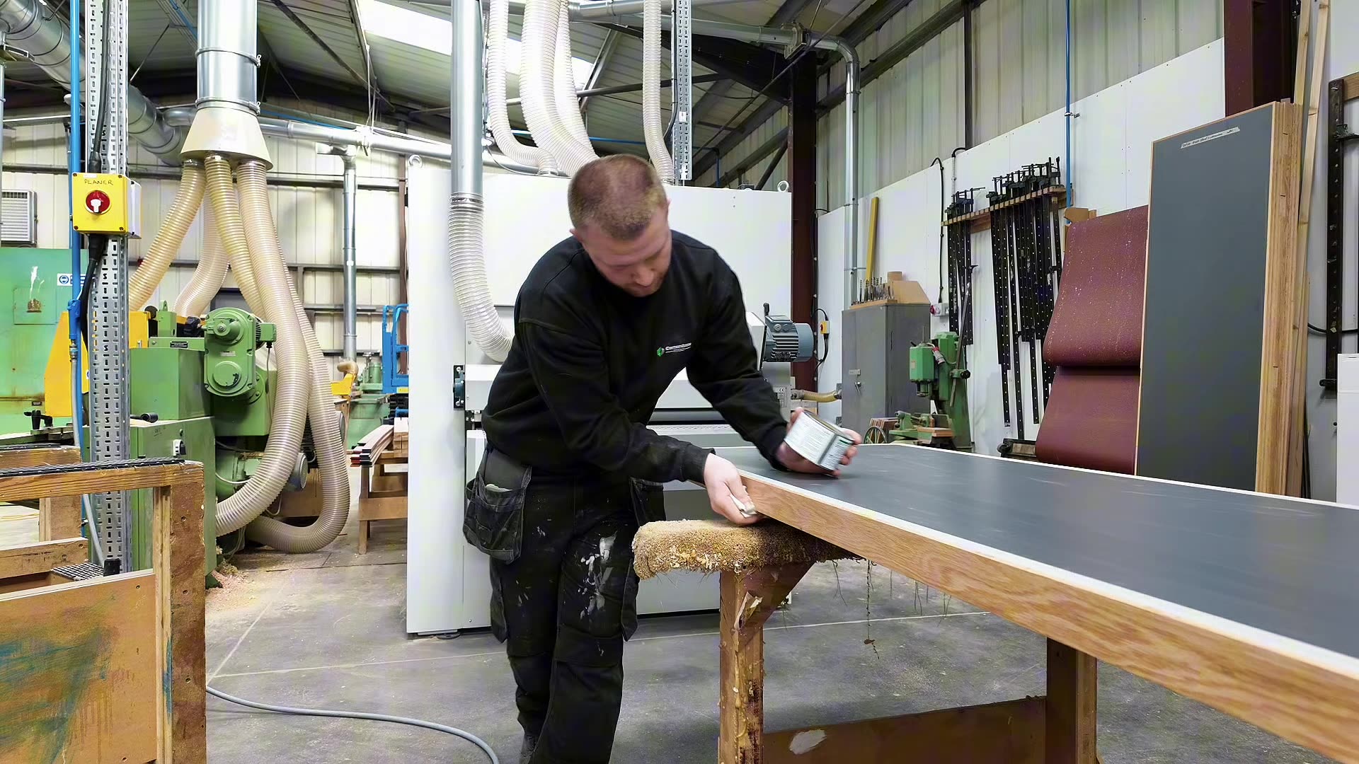 A Cornerstone joiner applying adhesive to a worktop edge in the company's Lancashire workshop