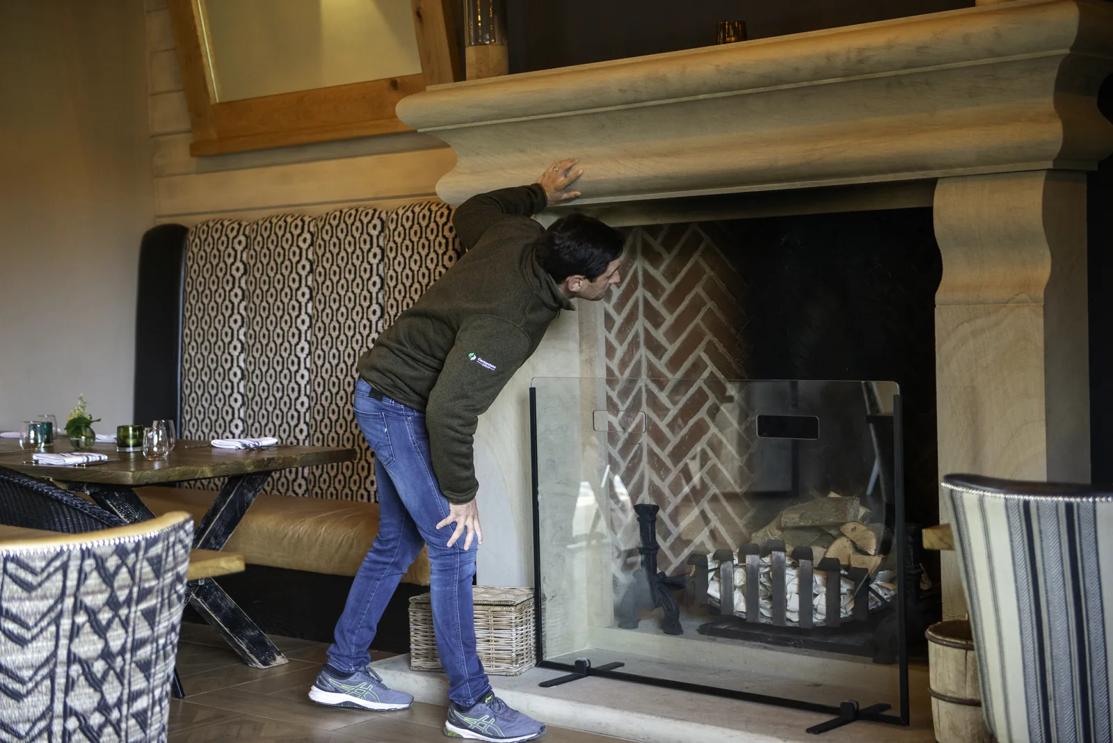 Cornerstone team member checking the stone fireplace surround
