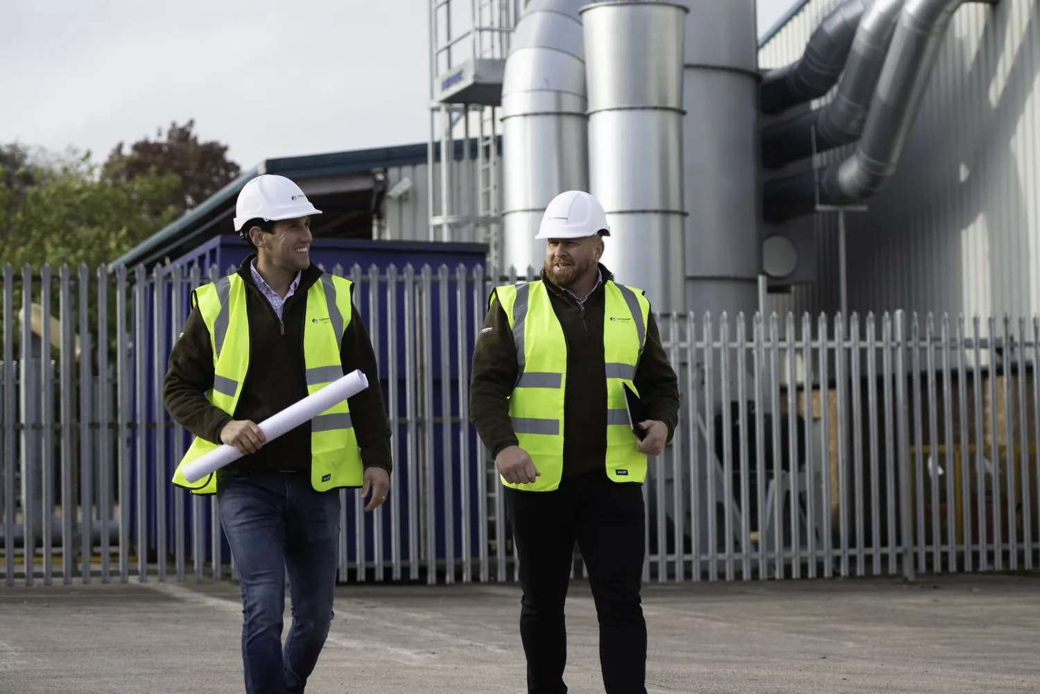 Cornerstone site managers walking past a manufacturing plant ahead of a commercial solar installation