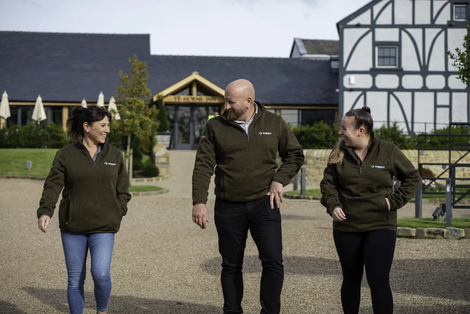 Cornerstone team walking towards Ye Horns Inn with its timber-framed gable behind