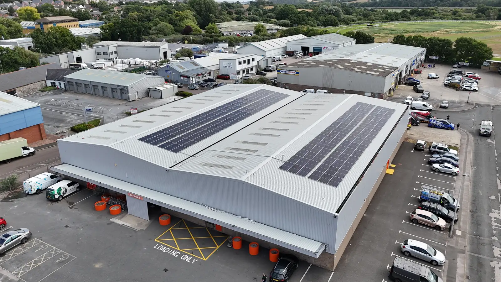 Drone shot of two solar arrays on a warehouse roof within an industrial estate